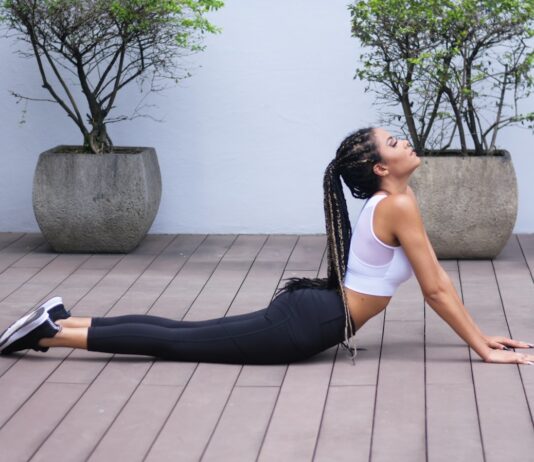 요가의 힘: 몸과 마음을 유연하게 만드는 방법” woman in white sports bra and black leggings doing yoga