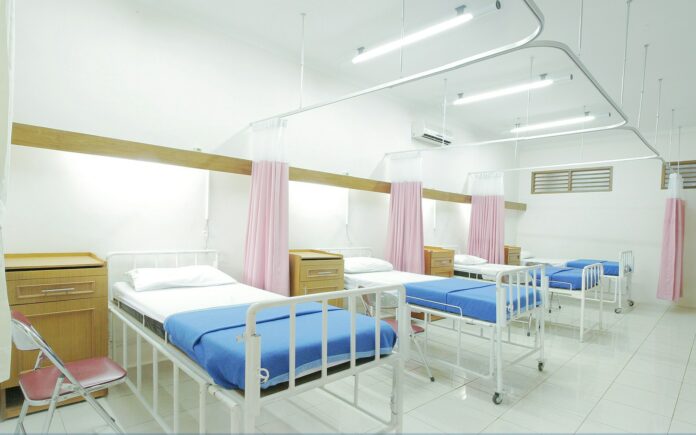 Photo by Adhy Savala empty hospital bed inside room