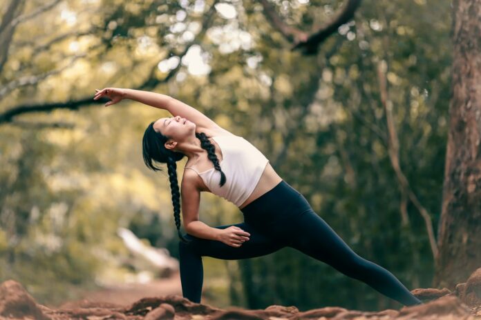 Photo by Luemen Rutkowski woman in white tank top and black leggings doing yoga during daytime