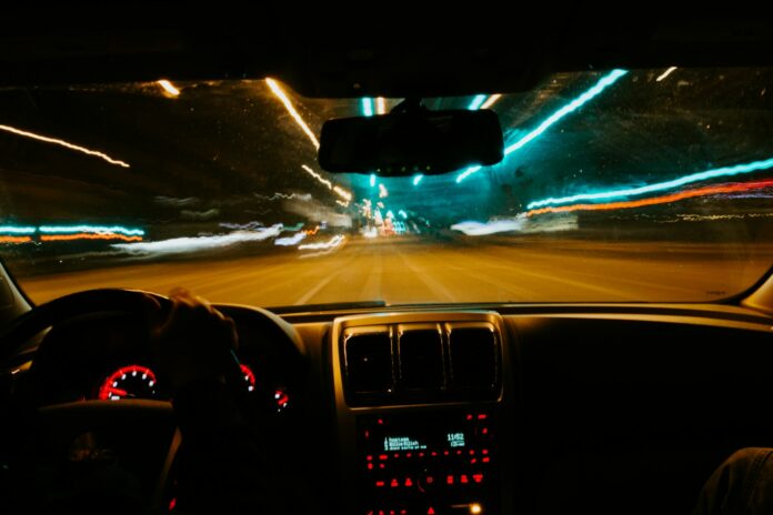 Photo by Gabe Pierce person driving car during night time