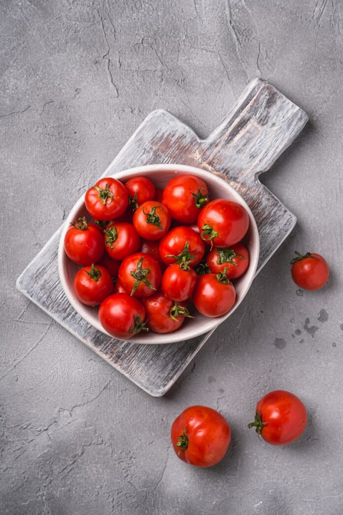 Photo by Rodion Kutsaiev a bowl of tomatoes on a cutting board