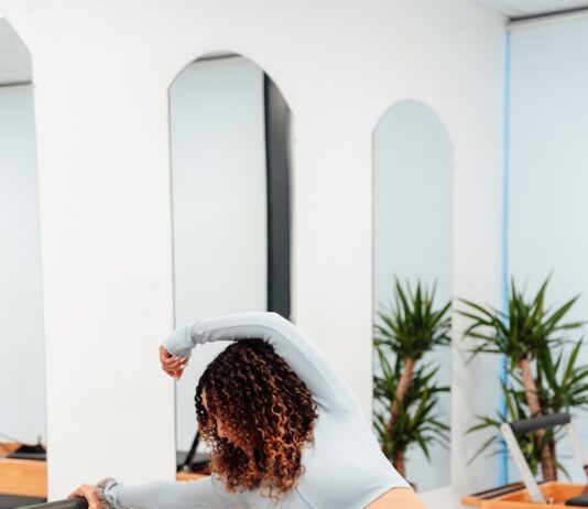 필라테스로 코어 강화, 바른 자세와 몸의 균형 유지하기 a woman is doing exercises on a rowing machine