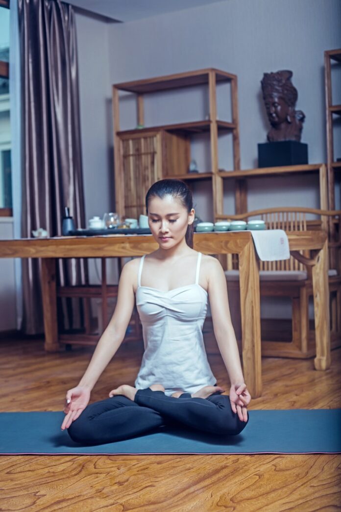Photo by Alex Shaw woman in white tank top sitting on brown wooden chair