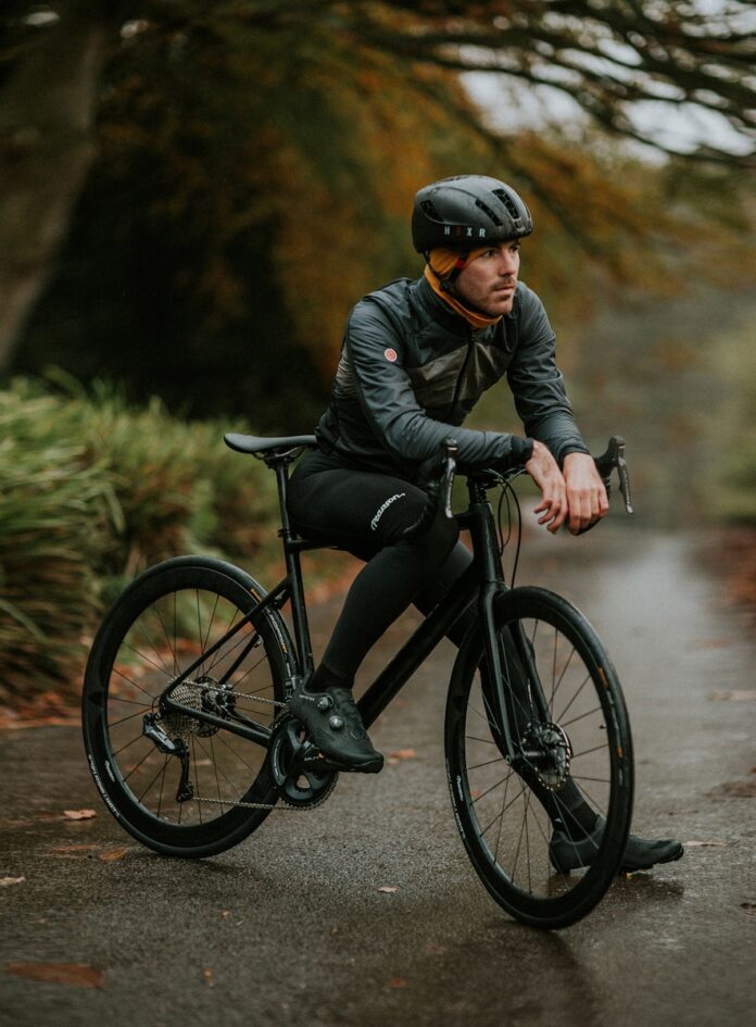 Photo by Zoltan Tasi man sitting on road bike near trees