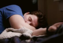 잠을 줄이는 방법 woman in blue shirt lying on bed