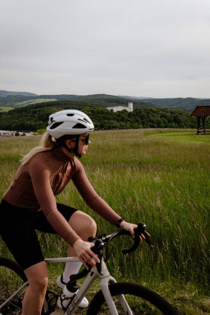 Photo by Tomáš Jančařík A woman riding a bike down a dirt road