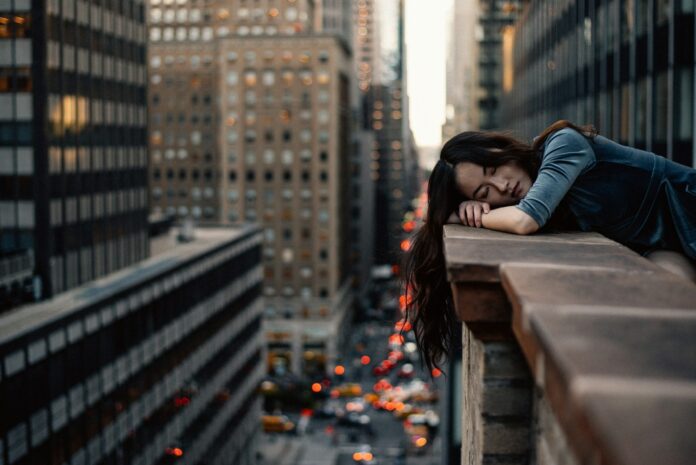 Photo by Hernan Sanchez woman leaning on top building rail during daytime