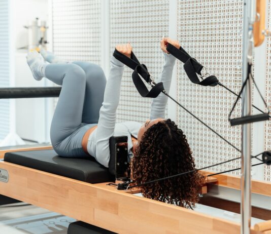 헬스 트렌드 중 하나, 필라테스 a woman is doing exercises on a rowing machine