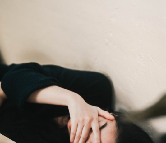 만성피로, 단순한 피로가 아닌 ‘경고 신호’…원인과 극복 방법은? woman in black long sleeve shirt covering her face