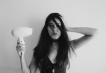 건강한 모발을 위한 올바른 관리법과 습관 woman in black tank top holding her hair