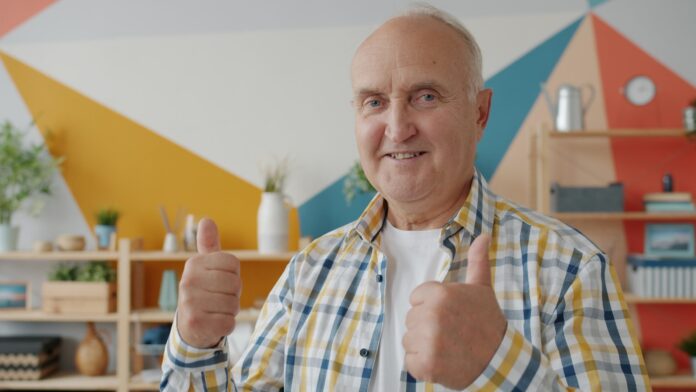 Photo by Vitaly Gariev Smiling older man gives two thumbs up.