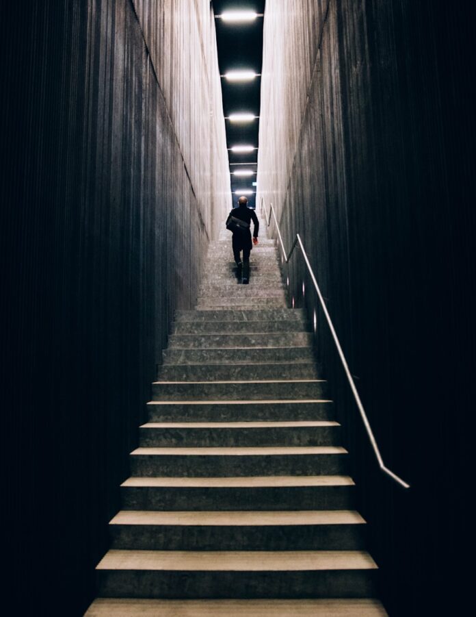 man in black pants going down stairs